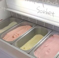 three pans filled with ice cream sitting on top of a counter