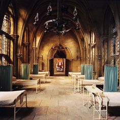 an old church with many beds and chairs in it's center aisle, as well as a chandelier hanging from the ceiling