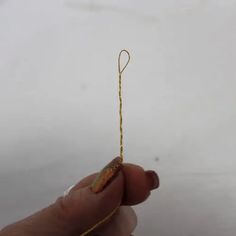 a hand holding a string that is yellow and red