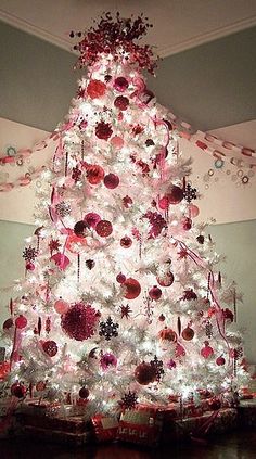 a white christmas tree decorated with red and silver ornaments