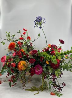 a vase filled with lots of different colored flowers