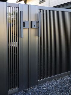 a metal gate is open on the side of a house