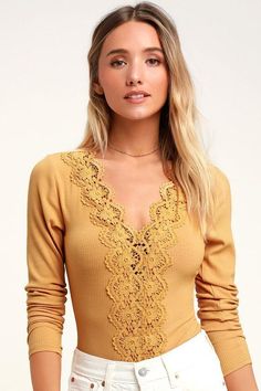 Lulus Exclusive! Keep 'em coming back for more with the Lulus Come Back To You Mustard Yellow Lace Long Sleeve Bodysuit! Lovely crochet lace accents the V-neck and bodice of this sexy little bodysuit with fitted, long sleeves and a ribbed knit construction. Thong bottoms (with two snap closures) make layering under skirts and high-waisted jeans a breeze. Fit: This garment fits true to size. Length: Size small measures 27" from shoulder to hem. Bust: Great for any cup size. Waist: Fitted - stretc