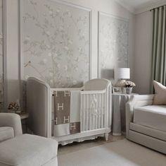 a baby's room with white furniture and flowers on the wall behind the crib