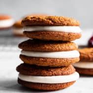 a stack of cookies with white frosting and cranberry on the top one