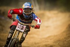 a man riding a dirt bike on top of a dirt field with an american flag painted on it