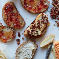 several slices of pizza with toppings on them sitting on a white table top next to sliced bananas and pecans