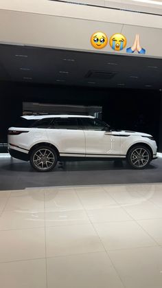 a white range rover is parked in front of a building with emoticions on it