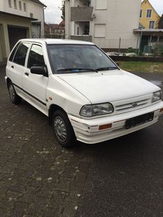 a white car is parked in front of some houses