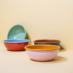 three different colored bowls sitting next to each other