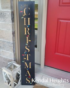 a sign that says merry christmas on it next to a red door and brick wall