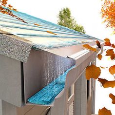 an image of water coming out of the gutter in front of a house with autumn leaves around it