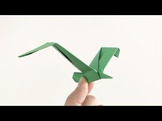 a hand is holding an origami bird in the shape of a letter k