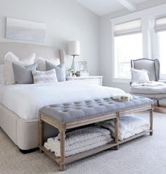 a bedroom with a bed, chandelier and two windows in the ceiling area