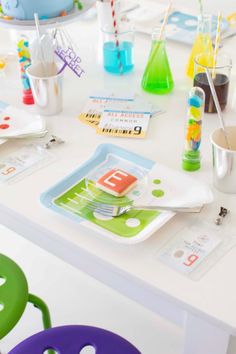 the table is set with colorful plates, cups and utensils for children to eat