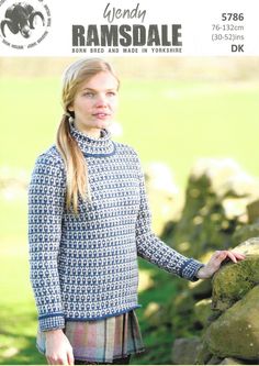 a woman wearing a blue sweater and standing next to a stone wall with the text free pattern