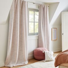 a bedroom with a bed, window and rug on the floor in front of it