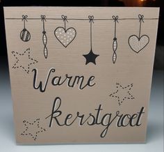 a sign that says warme kerstsgat hanging from a line with hearts and stars