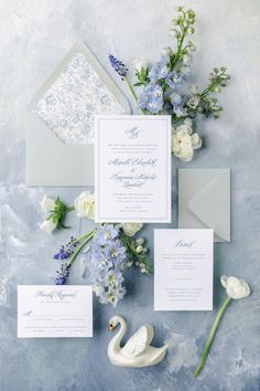 the wedding stationery is laid out with flowers and an envelope