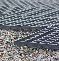 there is a grate laying on the ground with rocks and gravel in front of it