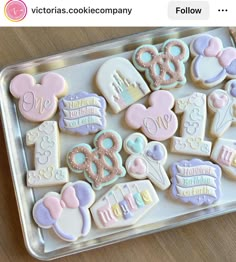 some decorated cookies in a plastic tray on a wooden table with the caption victoria's cookie company follow