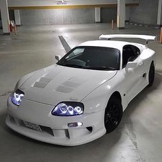 a white sports car parked in a parking garage