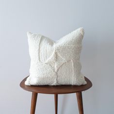 a white pillow sitting on top of a wooden table