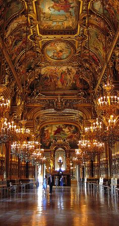 an ornately decorated hall with chandeliers and paintings on the ceiling is shown