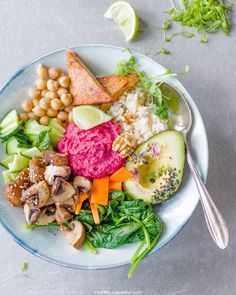 a white plate topped with different types of food next to a fork and spoon on top of a table