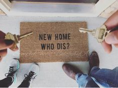 two people holding keys to a door mat that says new home who dis?