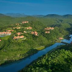 an aerial view of a resort surrounded by lush green hills