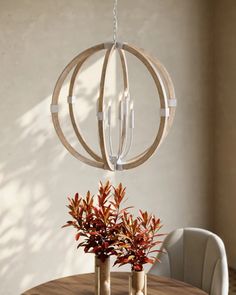 a wooden table with two vases on it and a chandelier hanging from the ceiling