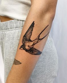 a small bird tattoo on the arm