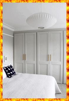 a white bed sitting in a bedroom next to a fire effect frame on the wall