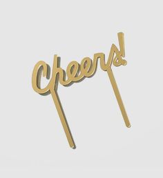 the word cheers is made out of gold colored cake sticks and sits on a white surface