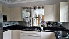 a kitchen with white cabinets and black counter tops