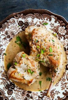 two pieces of chicken covered in gravy on a plate