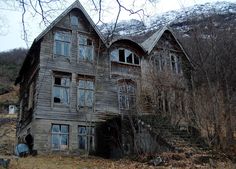 an old abandoned house sitting in the middle of a forest with no leaves on it