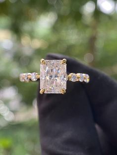 an engagement ring with a princess cut diamond surrounded by small white and yellow diamonds on it