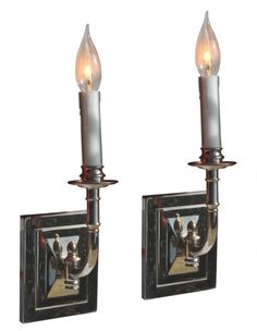 two light wall sconces with candles on them