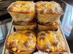 there are several muffins stacked on top of each other with cheese and meat in them