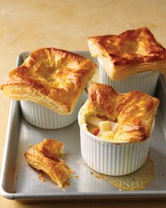 four small pies sitting on top of a metal tray