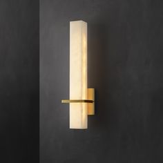 a wall light that is mounted on the side of a wall in a dark room