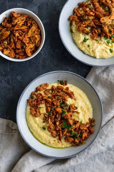 two white bowls filled with mashed potatoes and meat