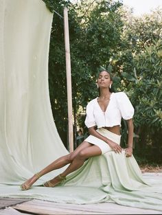 a woman sitting on top of a green blanket