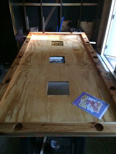 there is a wooden table that has been built into the floor with some tools on it