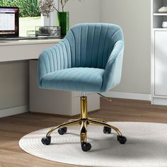 a blue chair sitting on top of a white rug in front of a computer desk