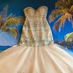 a dress is displayed in front of palm trees