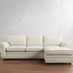 a white couch sitting on top of a hard wood floor