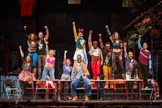 a group of people standing on top of a stage with their arms in the air